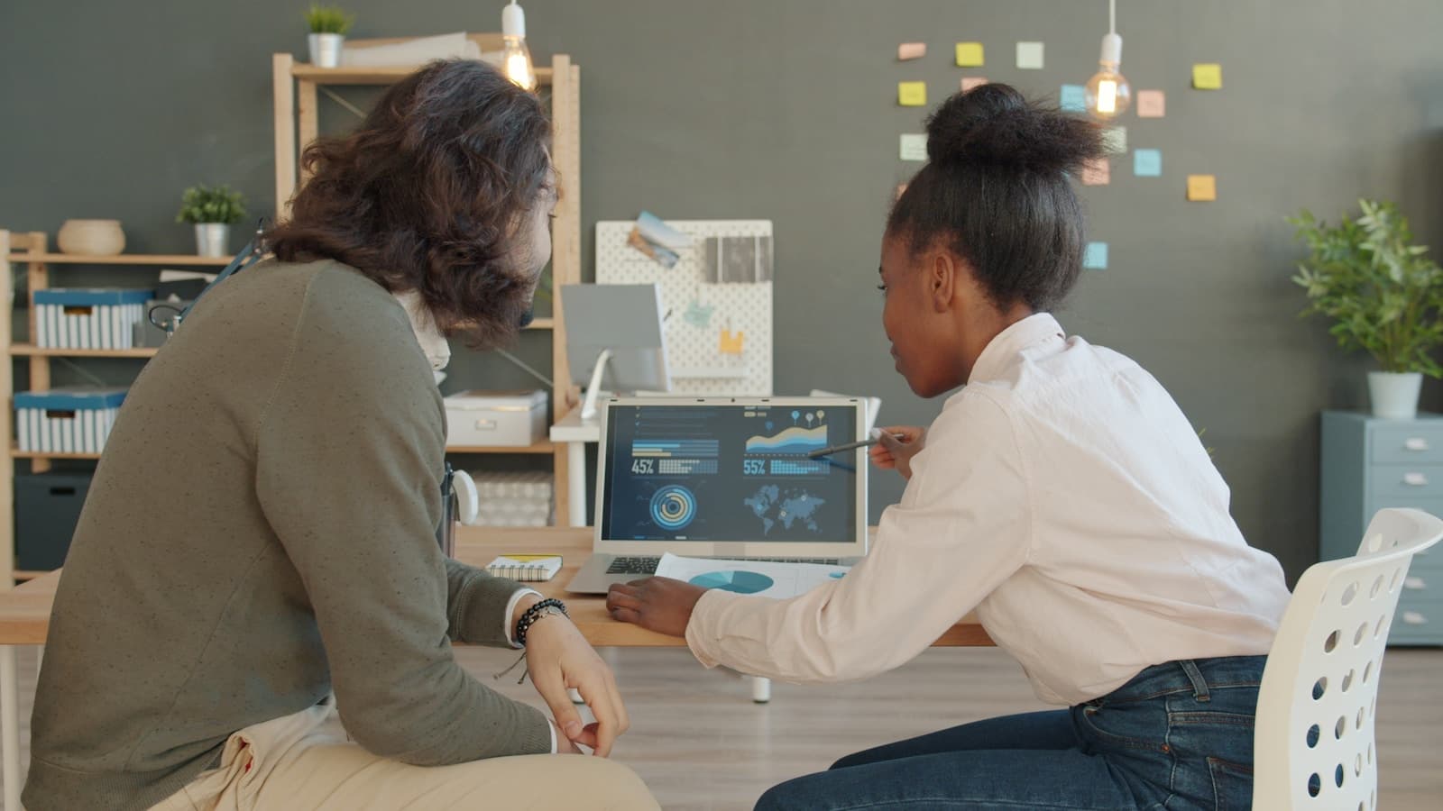 Two professionals reviewing a workplace presentation during a focused communication session